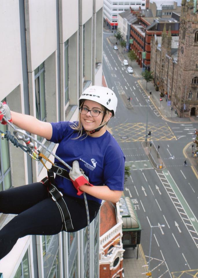 Fundraiser abseiling down a building wearing a Niamh Louise Foundation t-shirt