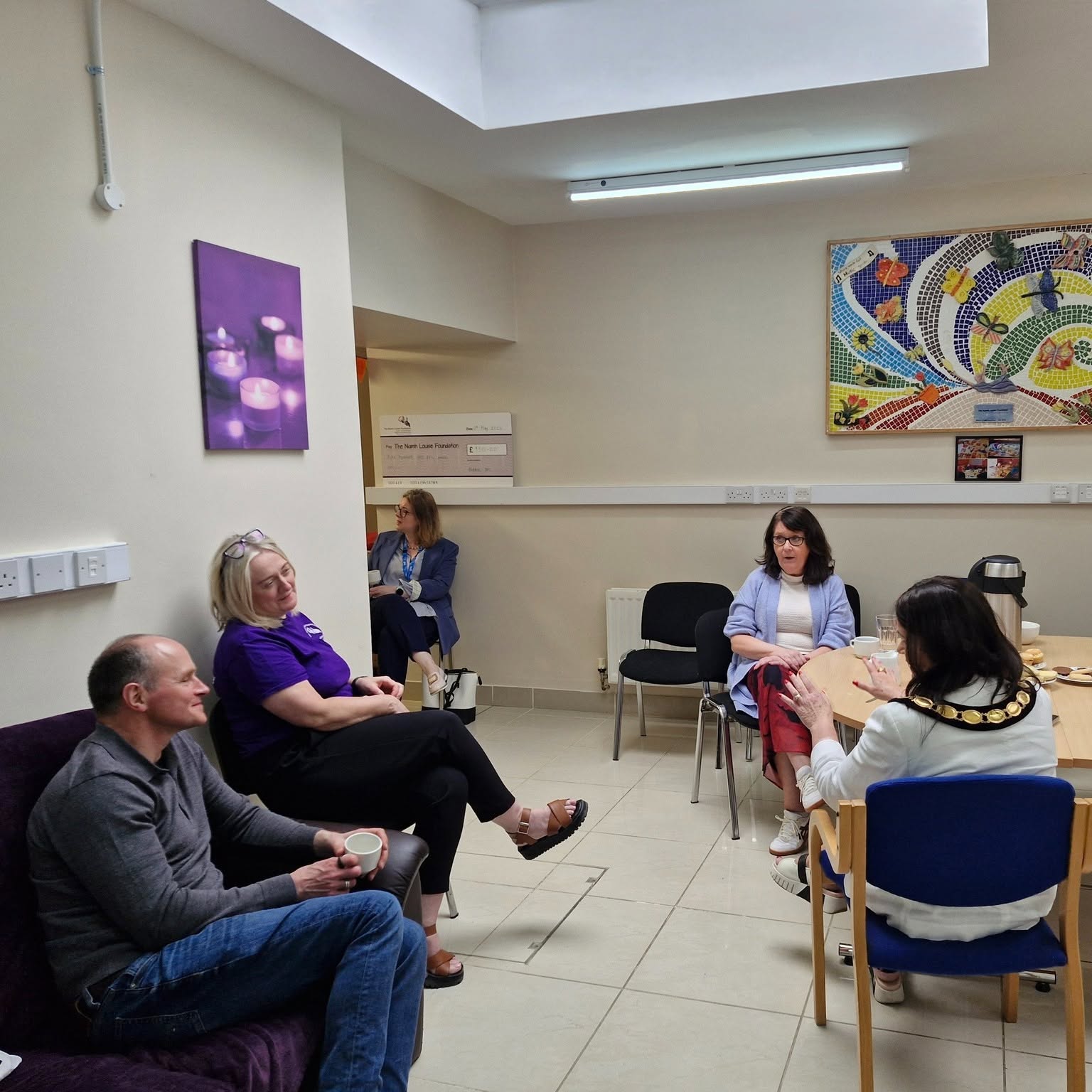 People sharing conversation and support over coffee at the Niamh Louise Foundation centre